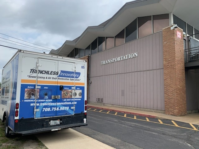 Trenchless Innovations service truck parked outside a school district transportation building near Chicago, ready for a trenchless sewer repair project.