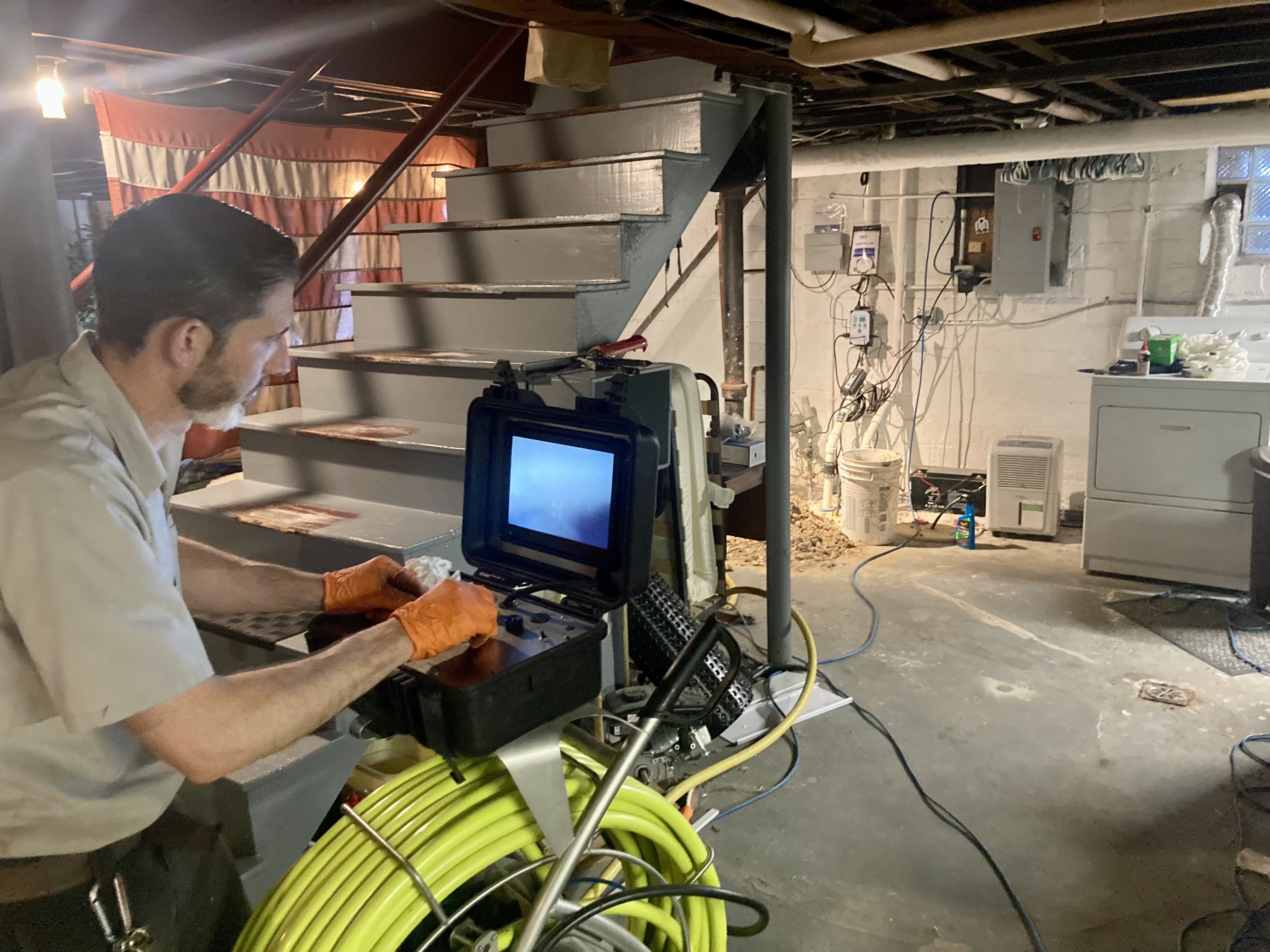 Technician running a sewer camera inspection in a homeowner’s basement