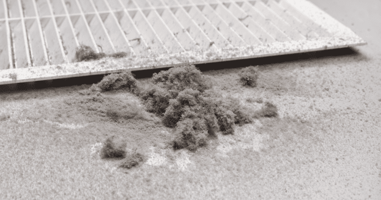 Dust buildup around a dirty air vent — a sign it’s time for an air duct inspection